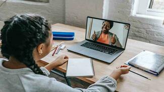 Child home tutored by teacher using laptop